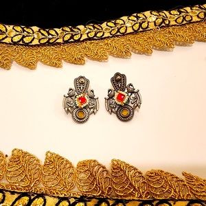 pair of earrings, with striking red stones, adding a touch of elegance